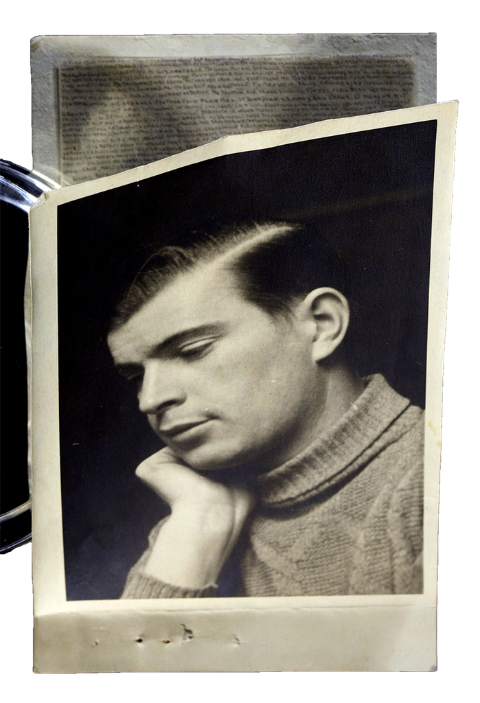 A photograph of a man with his face resting on his hand. A hidden message is viable on the inside.