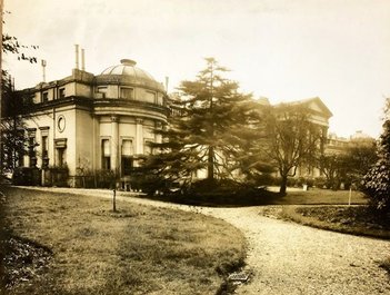 Exterior view of a large building with extensive grounds.